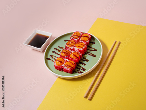 Glistening sashimi rolls served with dipping sauce on pastel dish