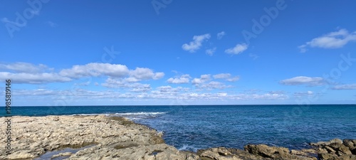 Obraz na plátně Panoramic view of a rocky breakwater protecting a calm coastal inlet
