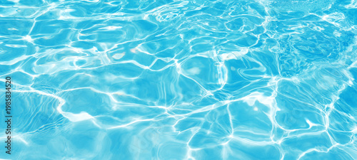 Close-up abstract texture of clear blue water with bright sun reflections in Phuket, Thailand.