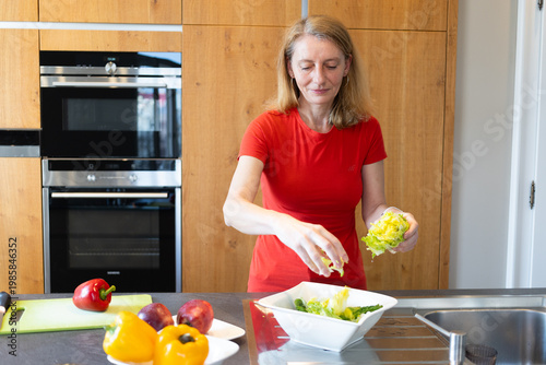 happy woman in her forties making a salad