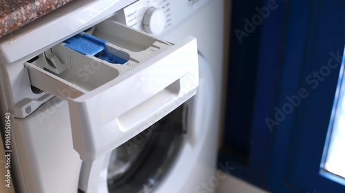 Tableau sur toile Close-up view of a washing machine detergent drawer with blue compartment, set a
