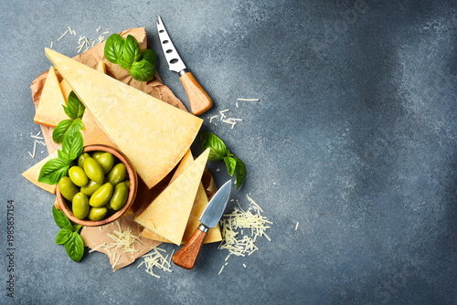 Set of hard cheeses with cheese knives on stone background. Parmesan. Top view. Free space for your text.