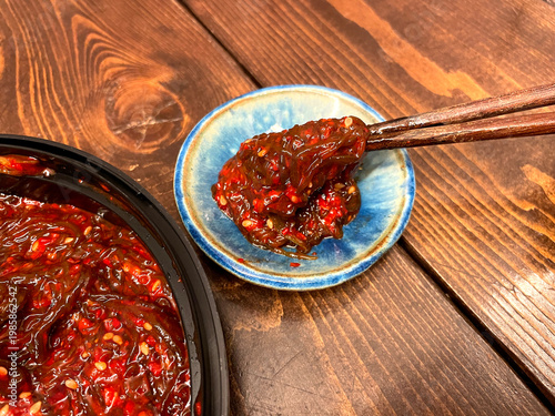 Wallpaper Mural 完熟もずくキムチ（沖縄産）─ 青い小皿と箸でつまむアップ Torontodigital.ca