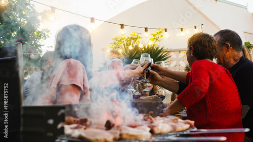 Group of friends having fun at barbecue dinner cheering with red wine - Food, friendship, and summer people lifestyle concept - Focus on hands clinking