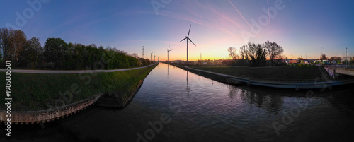Wind turbines and canal at sunset panorama in Rotselaar, Belgium