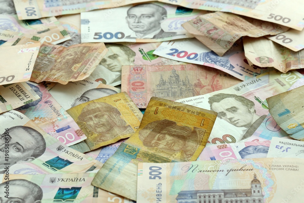 Obraz premium Ukrainian hryvnia money banknotes pile on table. Ukraine bills of UAH currency close up