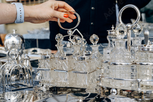 Fotografia Antique silver and cut crystal condiment set displayed on an ornate silver table, creating an elegant vintage look ideal for decor, collectables, table setting, flea market and luxury themes