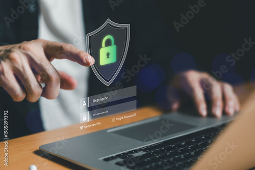 Hand interacting with secure login interface on laptop with shield and padlock icon, representing cybersecurity, data protection, password security, and safe online authentication