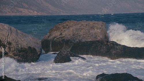 Close, slow motion shot of waves crashing on rocks 