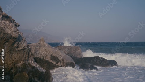 Waves crashing on a rocky shore in slow motion