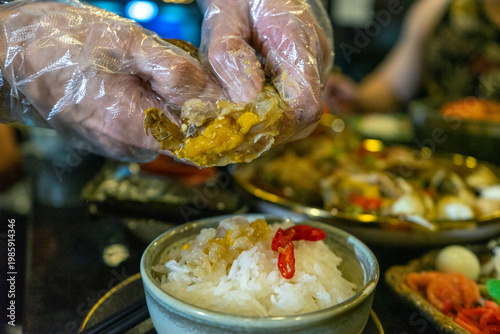 Gloved Hands Preparing Seafood and Rice Dish