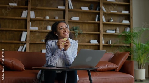 Woman celebrating successful online purchase on laptop
