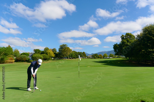 Bilde på lerret Man putting golf ball on green golf course.