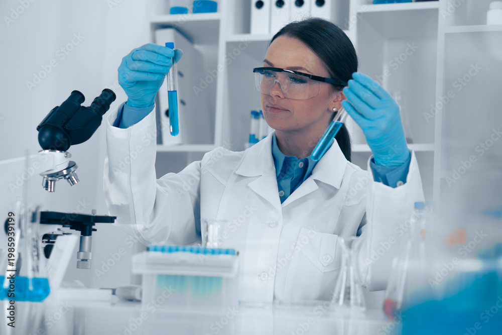 Fototapeta premium A dedicated lab technician in protective gear examines test tubes and samples in a wellequipped lab, highlighting the dynamic nature of ongoing scientific research and experimentation