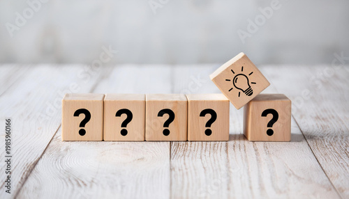 Creativity and Idea Concept – Light Bulb Block Among Question Marks on Wooden Background