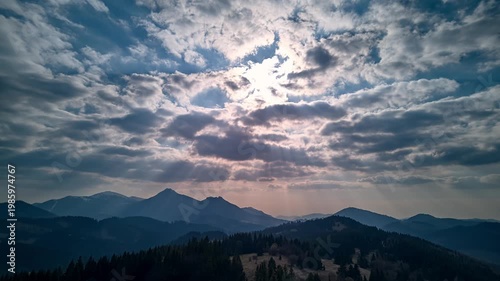 Aerial Hyperlapse of Sun Rays Breaking Through Clouds Over Mountain 