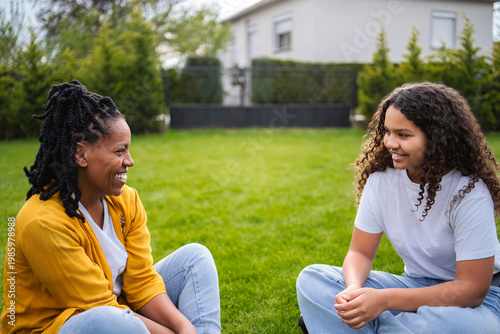 Mother and daughter having a meaningful conversation smiling outdoors