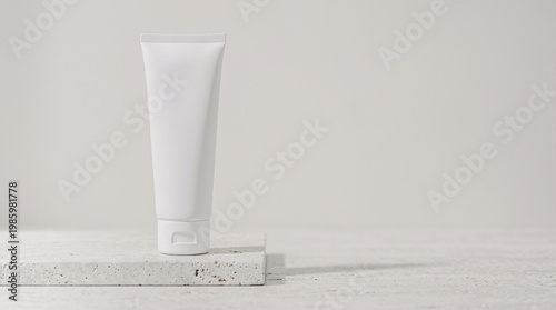White blank cosmetic tube standing on a natural stone podium against a light beige background with soft shadows. Minimalist design for beauty products or skincare mockup