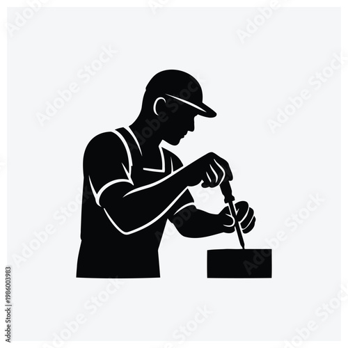 Silhouette of a man painting a surface with a brush.