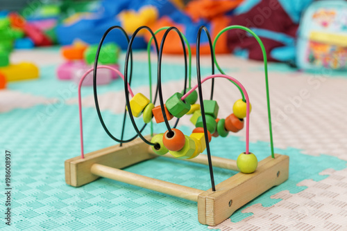 Colorful wooden bead maze toy on playroom floor