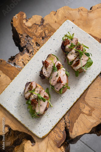 Toast with veal and sun-dried tomatoes, pesto sauce, garnished with peas microgreens top view
