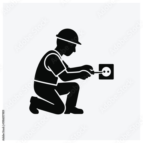 Silhouette of an electrician installing a wall outlet or electrical socket.