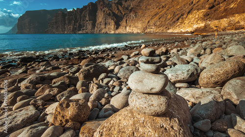 Balanced stones on Playa de Los Guios Beach with Los Gigantes Cliffs, Tenerife, Canary Islands, Spain