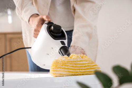 Woman steam cleaning bathtu...