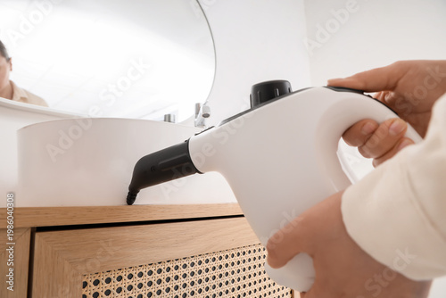 Female hands steam cleaning...