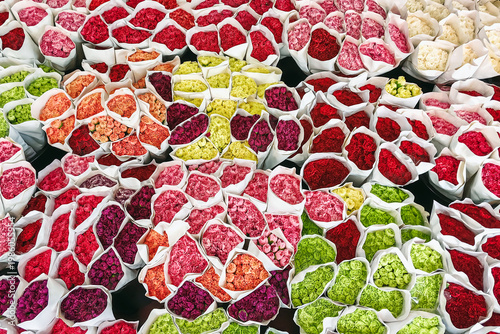 Top view of bouquets of colorful carnations. Many colorful flowers sale in paper packaging chrysanthemums, carnations and many other flowers. Mixed of brightly colored flower in paper packing for sale