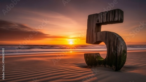 Rustic Wooden Number 5 Sculpture on a Sandy Beach at Sunset
