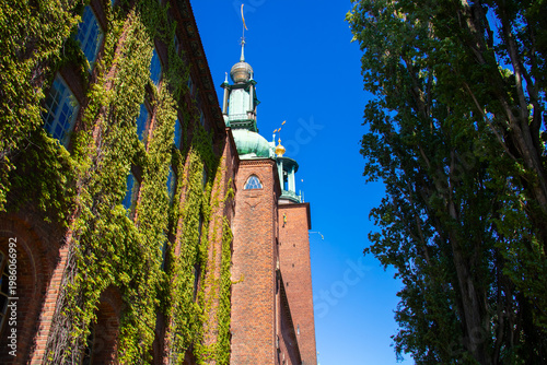 Photography Stockholm City Hall Surrounded by Trees and Greenery Under Blue Sky