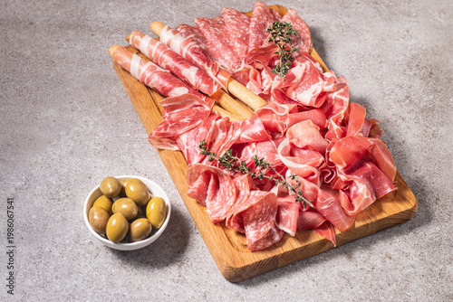 Charcuterie board. Antipasti appetizers of meat platter with salami, prosciutto crudo or jamon and olives.