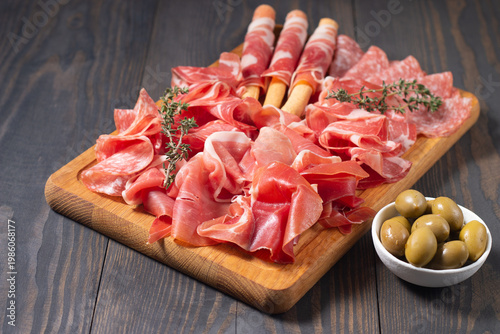 Charcuterie board. Antipasti appetizers of meat platter with salami, prosciutto crudo or jamon and olives.