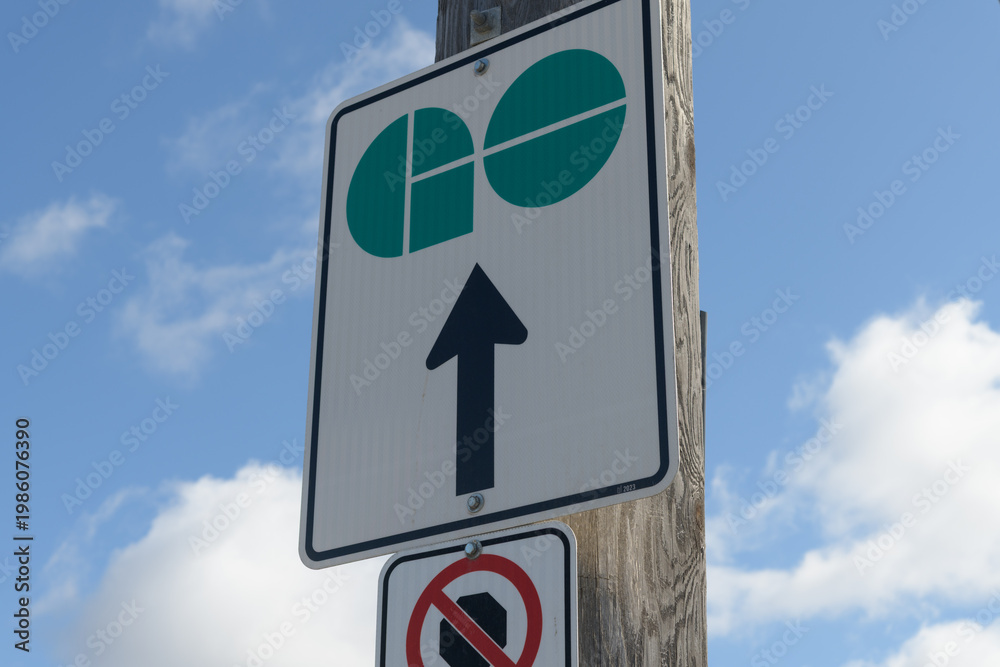 Fototapeta premium GO Transit logo sign on a cloudy blue sky in Toronto