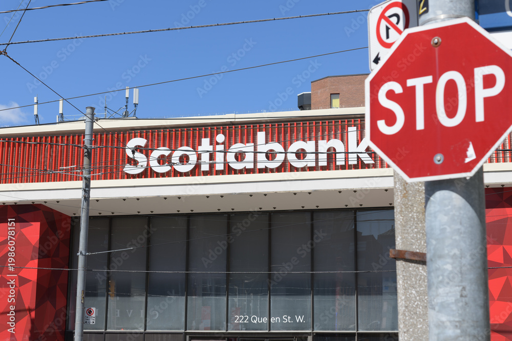 Obraz premium defocused stop sign and exterior building facade and sign of Scotiabank, a bank branch, located here at 222 Queen St W, Toronto