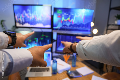 Hands of traders pointing a...