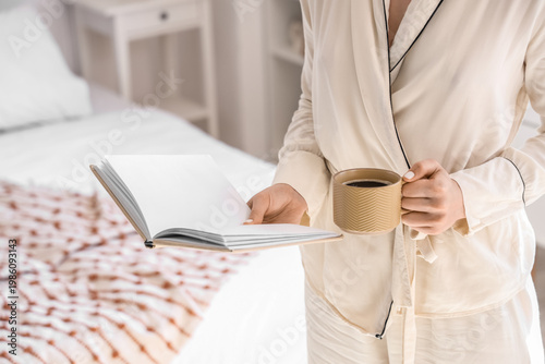 Young woman holding cup of ...