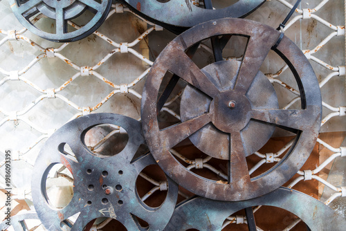 Multiple vintage metal movie film reels mounted on a decorative white lattice wall.