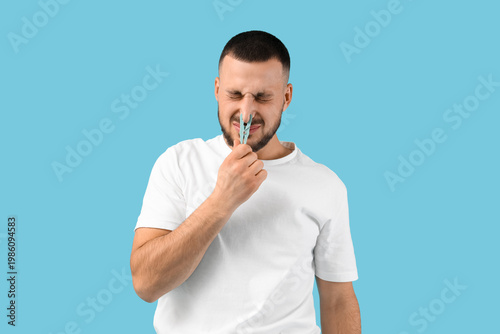Young man with clothespin o...