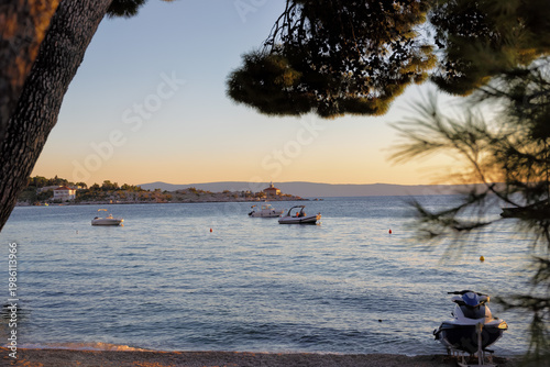 Sea with ships and beach of Makarska on the Riviera at sunset, in Dalmatia in late summer