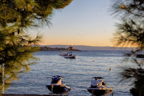 Sea with ships and beach of Makarska on the Riviera at sunset, in Dalmatia in late summer