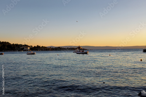 Sea with ships and beach of Makarska on the Riviera at sunset, in Dalmatia in late summer