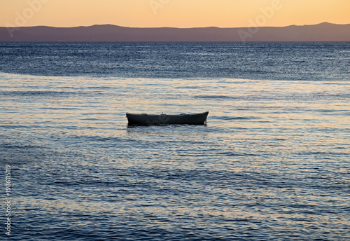 A single ship silhouette in the water off Makarska on the Riviera at sunset, in Dalmatia in late summer