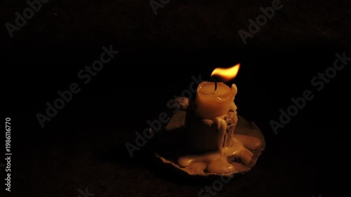 Candle in vintage candleholder on black background