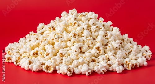 A large pile of freshly popped popcorn in a vibrant red background