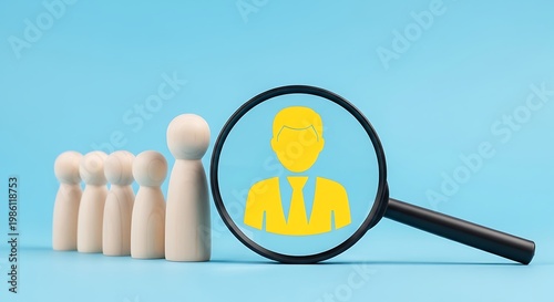 Business professional recruitment concept with magnifying glass focusing on a yellow silhouette of a man in a suit among wooden figures on a light blue background