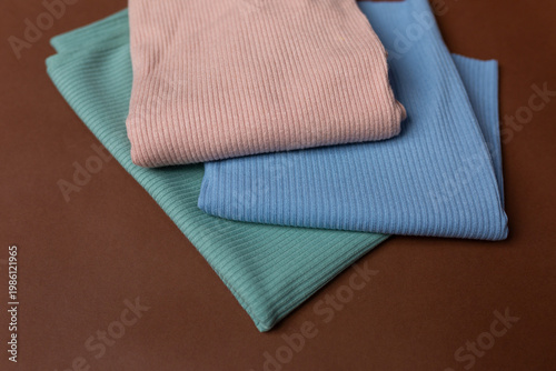three fabrics of different colors on a brown background