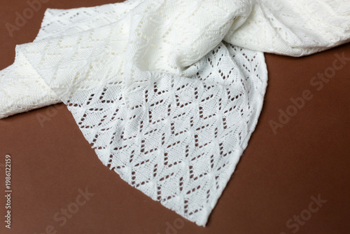 openwork knitted fabric on a brown background