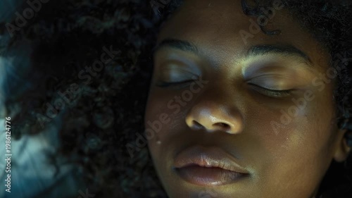 A close-up  of a woman with her eyes shut, perfect for representing relaxation, serenity or introspection